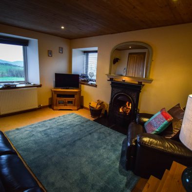 The spacious lounge with open fire at Gables Cottage, Polbain