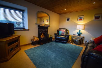 The spacious lounge with open fire at Gables Cottage, Polbain