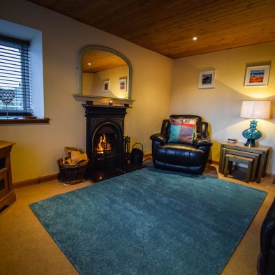 The spacious lounge with open fire at Gables Cottage, Polbain